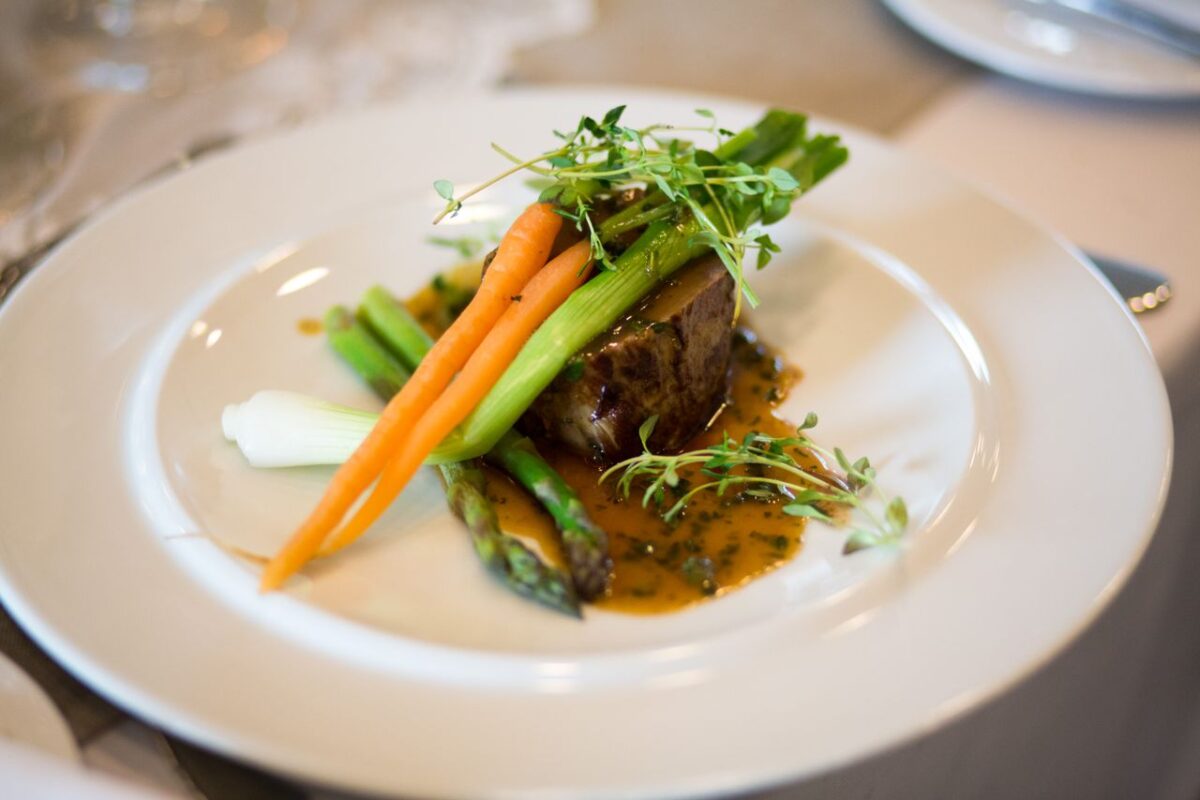 Luxurious gourmet meal elegantly plated with vegetables and sauce.