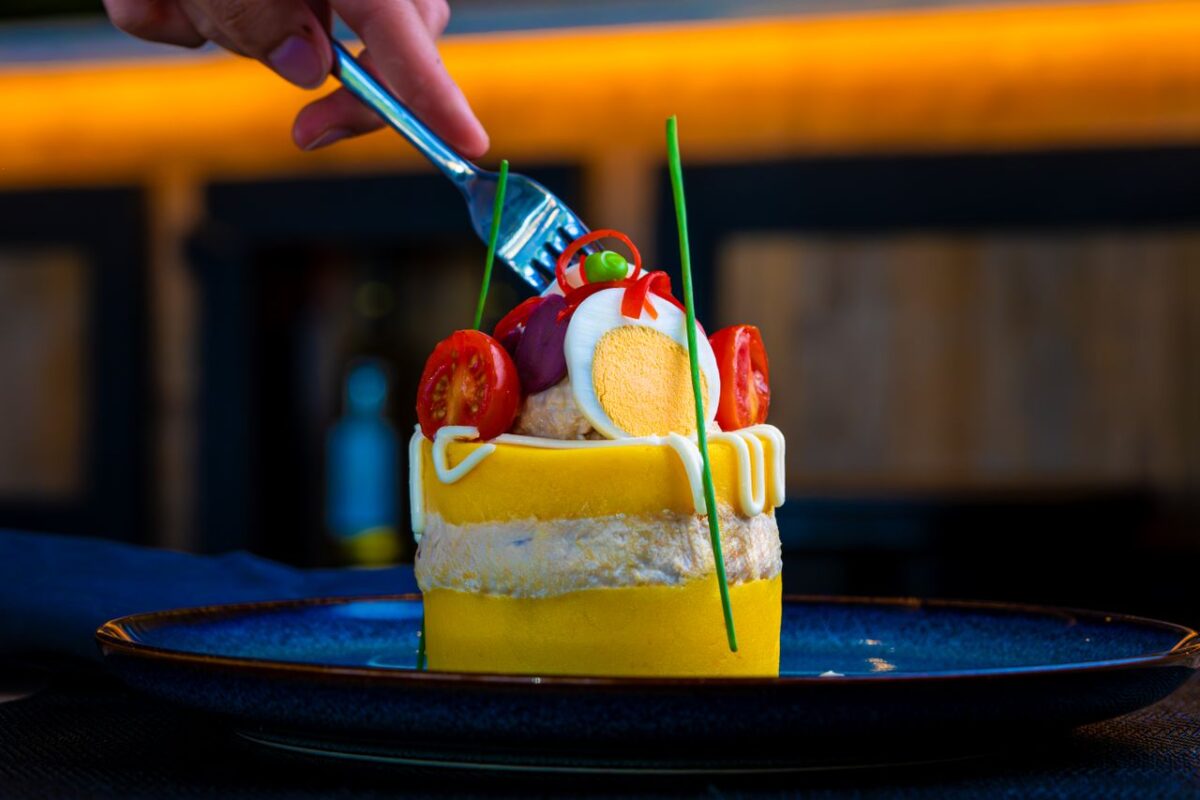 Close-up of a gourmet dish with eggs, tomatoes, and garnish, captured indoors.